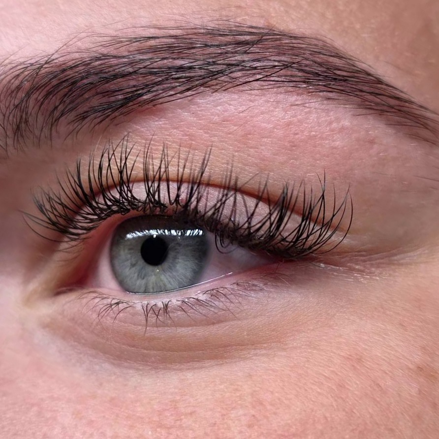 Close-up van een oog met verzorgde wenkbrauw en gelifte wimpers